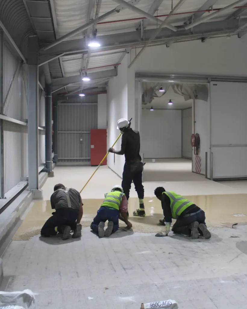 Team from epoxy flooring manufacturer Africa applying a durable floor in an industrial setting. Team from epoxy flooring manufacturer Africa applying a durable floor in an industrial setting.